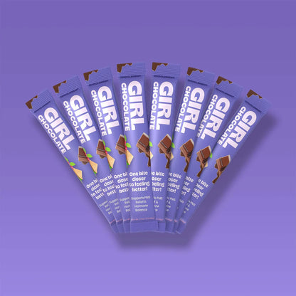 Multiple packages of Girl Chocolate on a purple background